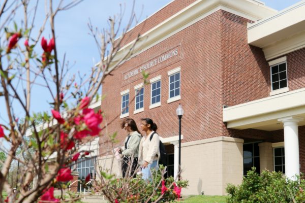 Picture of students walking past flowers in spring.